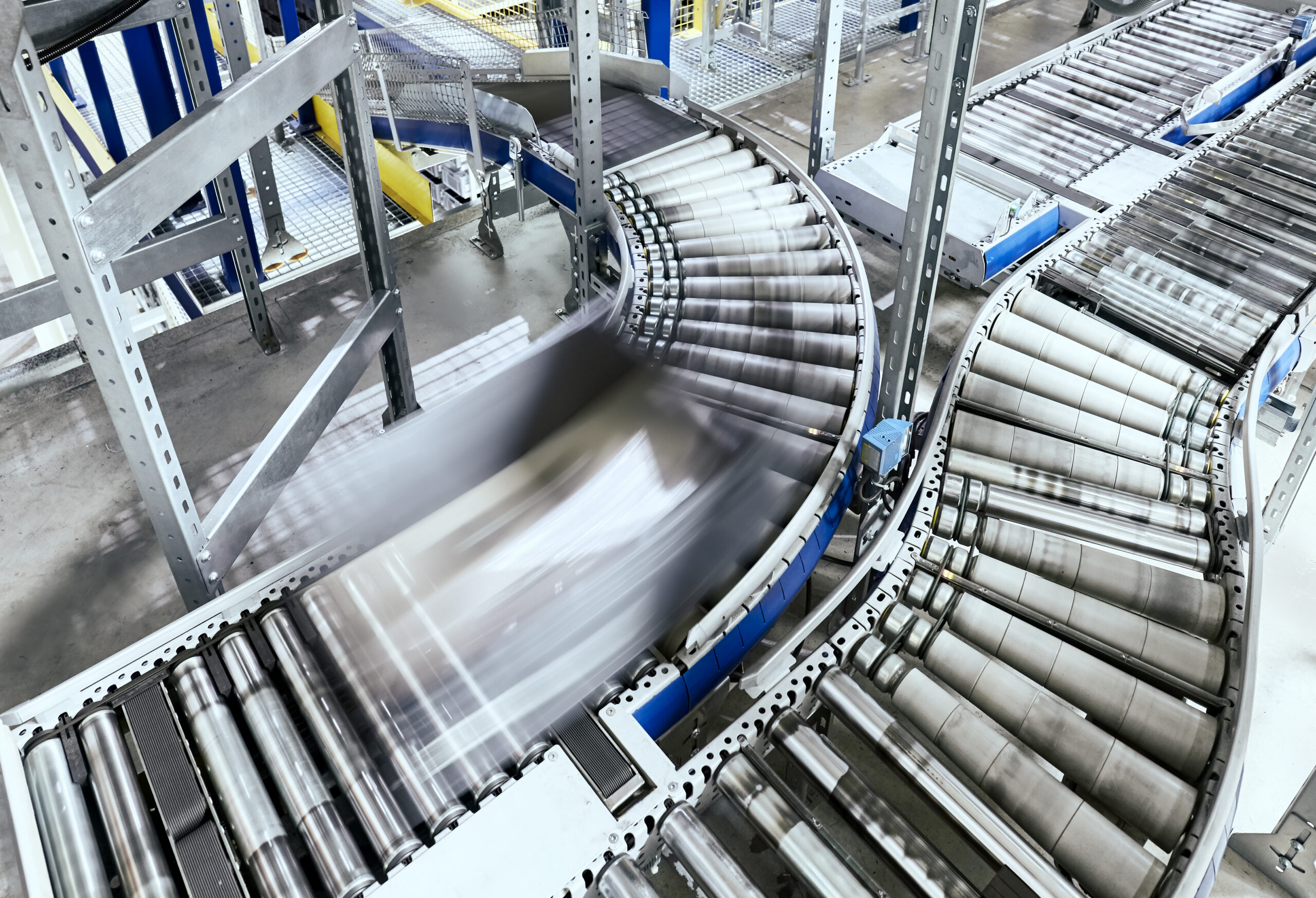 Transportation line conveyor roller with container in motion.